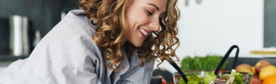 smiling-young-woman-using-smartphone-in-kitchen-3K5MASW.jpg